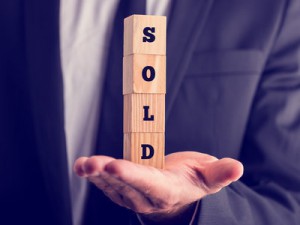 businessman holding a sold sign